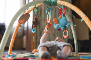 baby-lying-developing-rug-with-mobile-educational-toys Learning games for 6-month-old babies