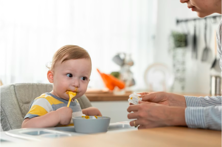 Infant being spoon-fed a smooth puree as part of homemade baby food recipes for 4-month-olds during the first stage of weaning.