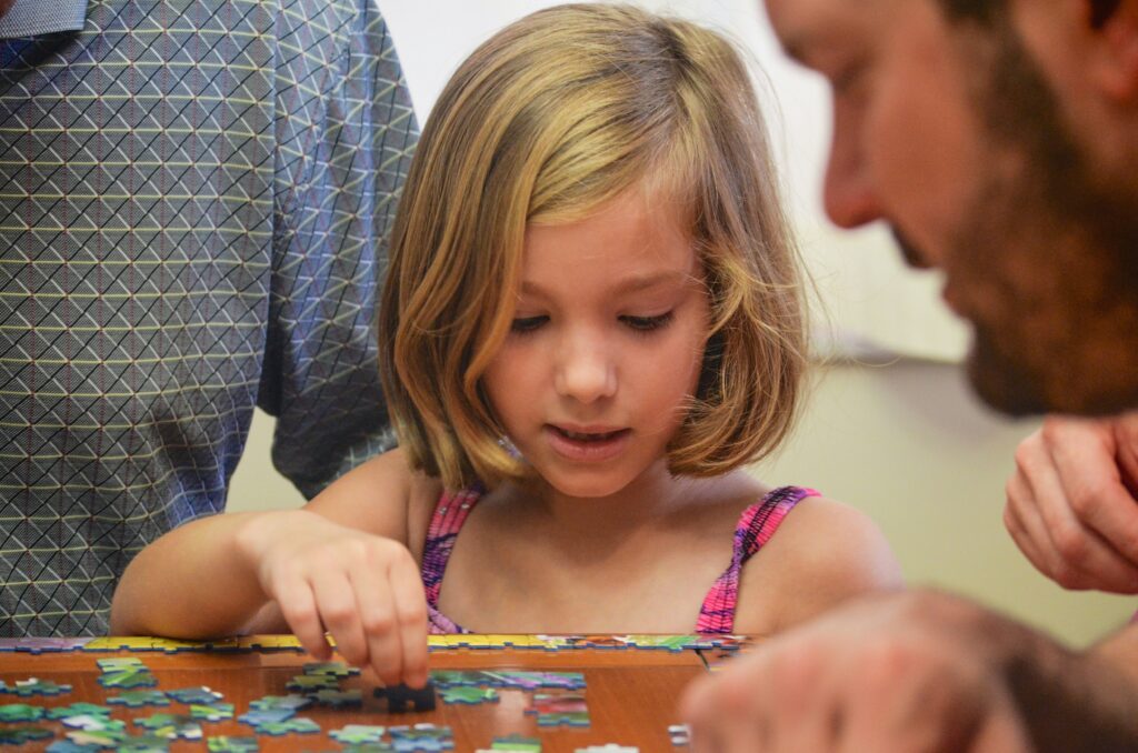 Father-daughter playing together puzzles